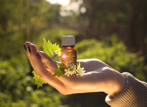 Photo d'illustration : une personne tient un flacon d'huiles essentielles dans sa main
